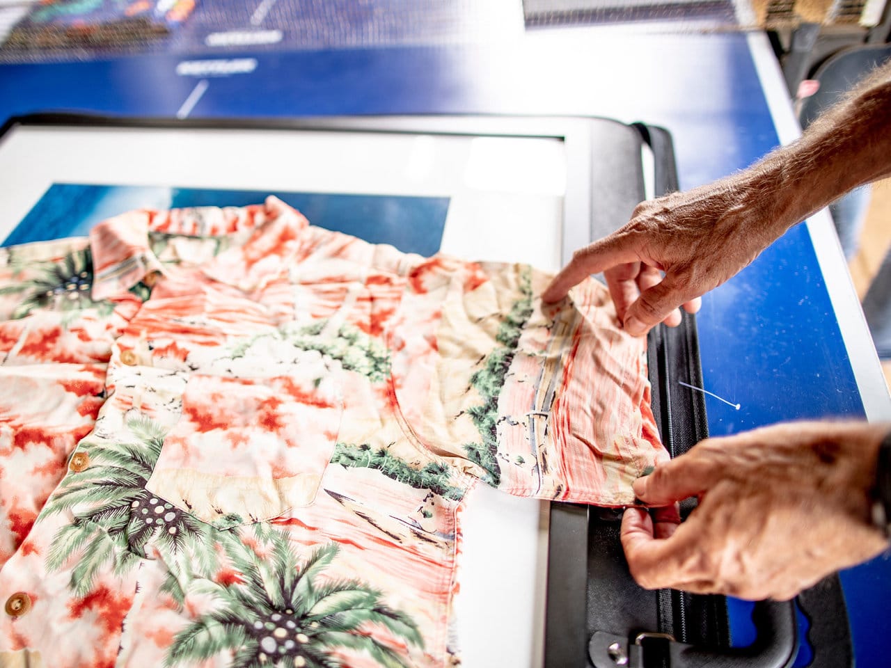 Hands pointing at print of Aloha shirt