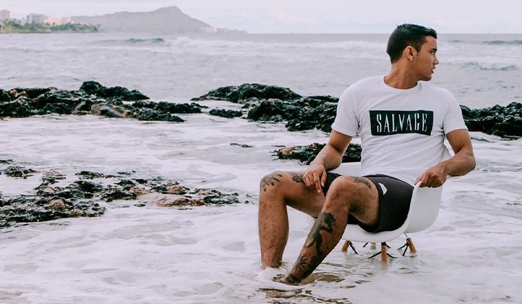 Savage Public photoshoot of man sitting in chair in the ocean