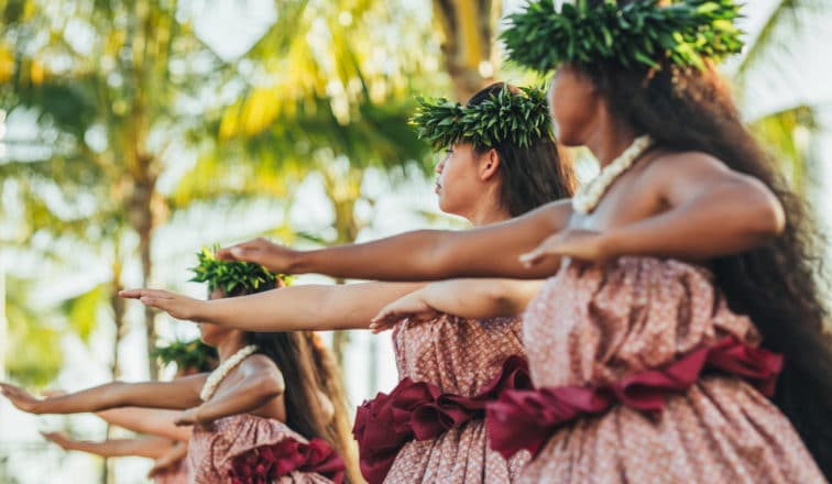 Five women dressed in traditional outfits hula with Lei Poʻo at Kona Nui Nights