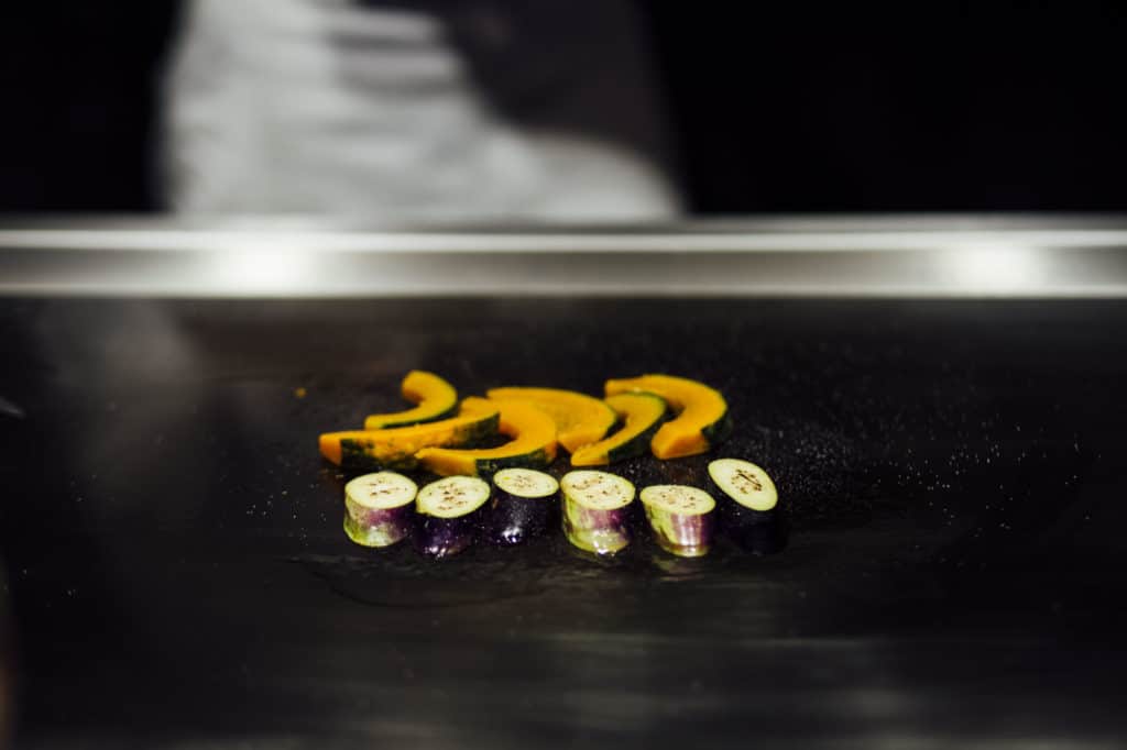 Sliced kabocha and eggplants on a grill