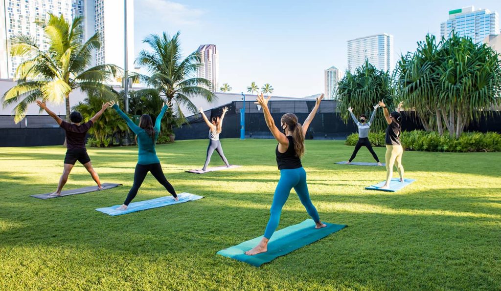 Yoga in the park under palm trees
