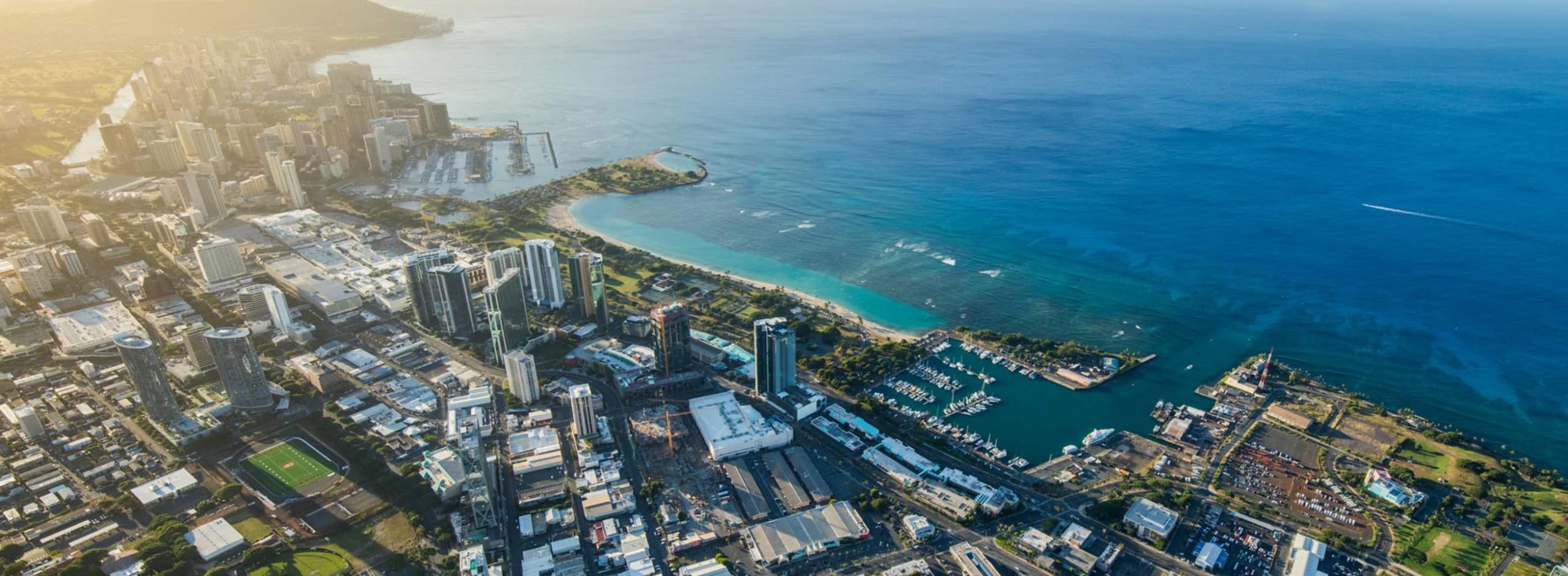 Aerial photo of a Honolulu harbor, ocean, and buildings