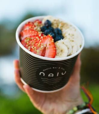 Nalu Health acai bowl topped with strawberries, blueberries, bananas and bee pollen