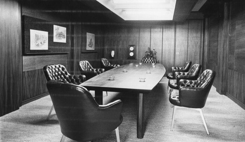 Inside the IBM Building, an empty conference room with mid-century office decor.